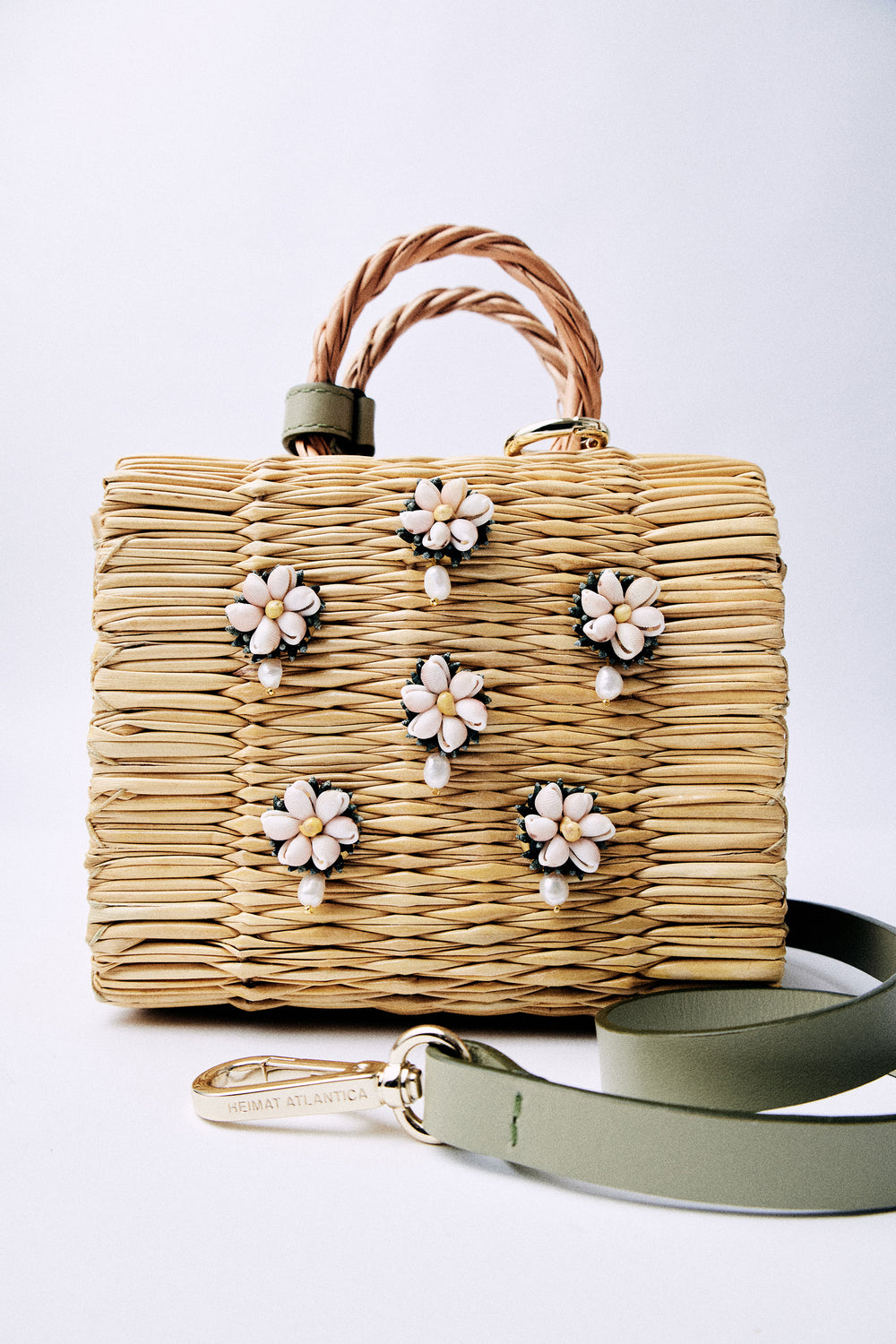 Mini Shella Valenitnie's basket bag by Heimat Atlantica, handwoven in Portugal from reed and finished in Spain with an Atlantic shell detail. general view detailed perals and strap in olive. 