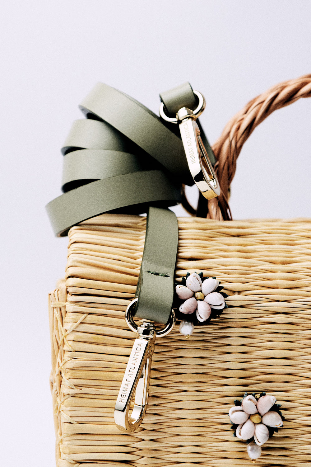 Large Shella basket bag by Heimat Atlantica, woven in Portugal and finished in Spain with Atlantic shell charm and leather details. Strap detail. 