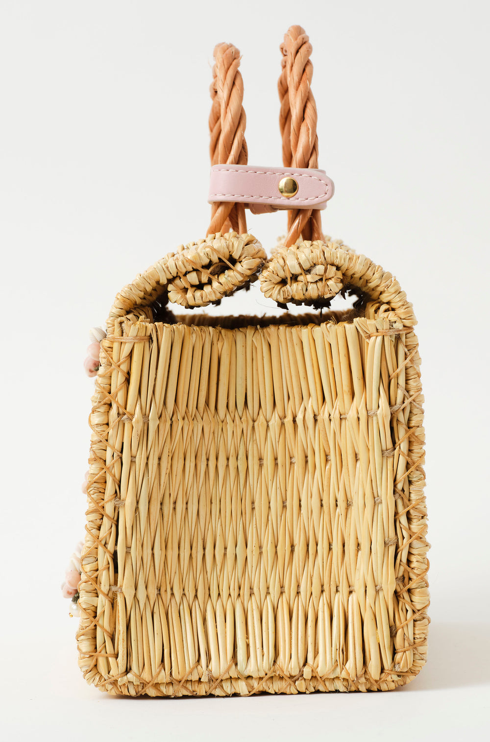 Wicker handbag with braided handle, light pink strap, and pastel floral decorations with pearl from the atlantic and leather in blush pink lateral with clousure detail