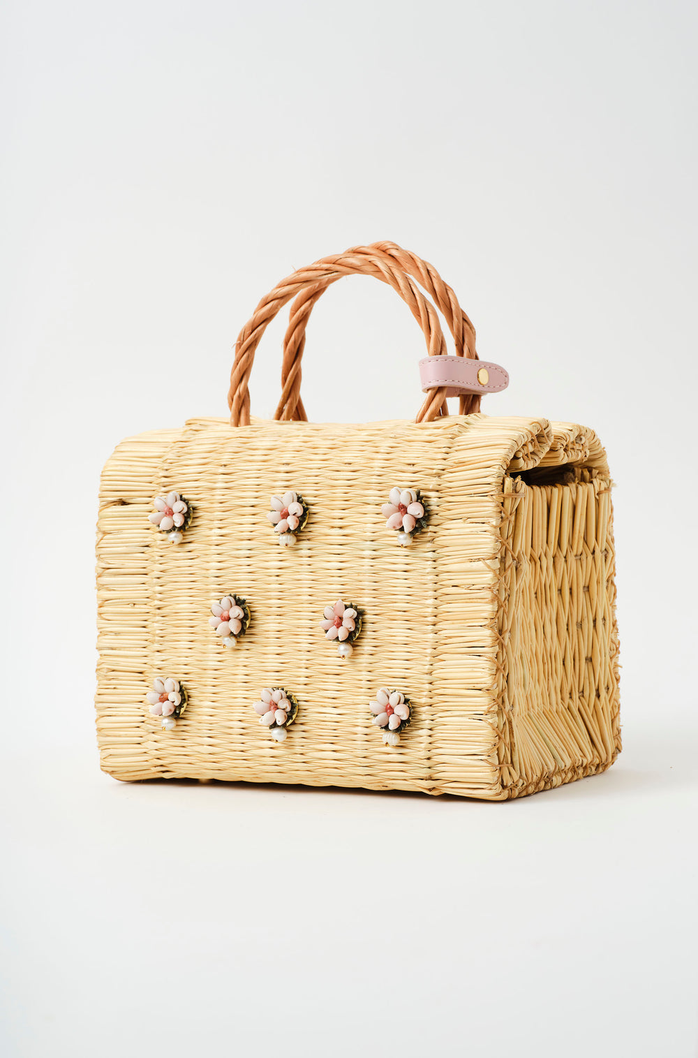 Wicker handbag with braided handle, light pink strap, and pastel floral decorations with pearl from the atlantic and leather in blush pink lateral detail
