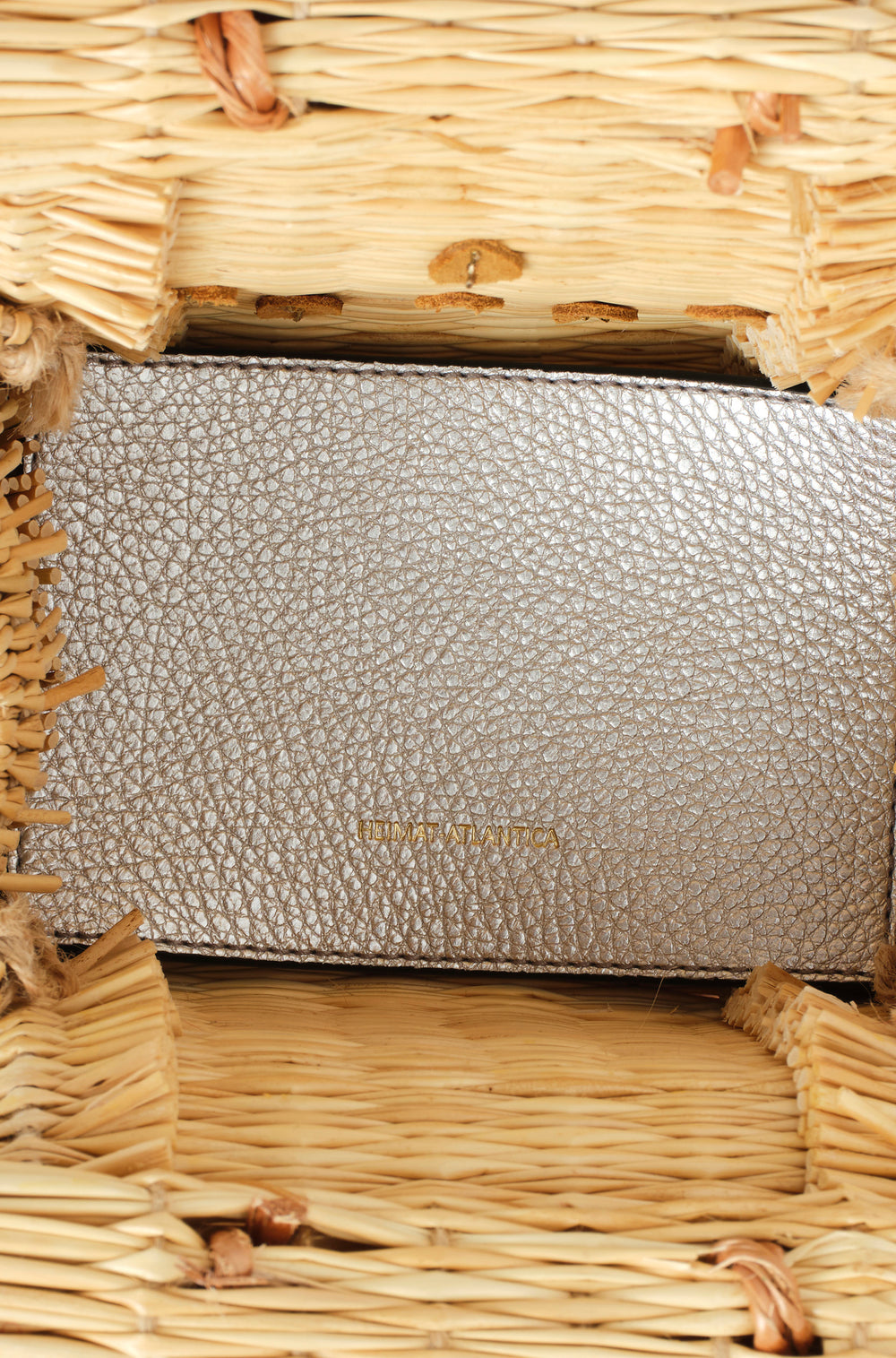 Shella Mini Silver basket bag by Heimat Atlantica, handwoven in Portugal from reed and finished in Spain with an Atlantic shell charm.  Inner detail in Silver. 