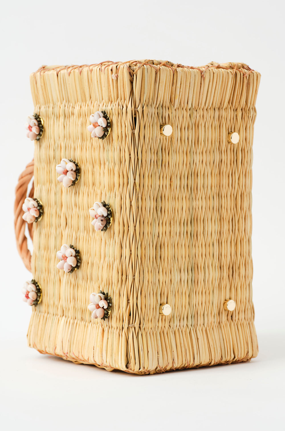 Shella basket bag by Heimat Atlantica photographed on the Atlantic coast between Spain and Portugal, celebrating shell craft, handmade tradition, and contemporary design with the feet in gold. 