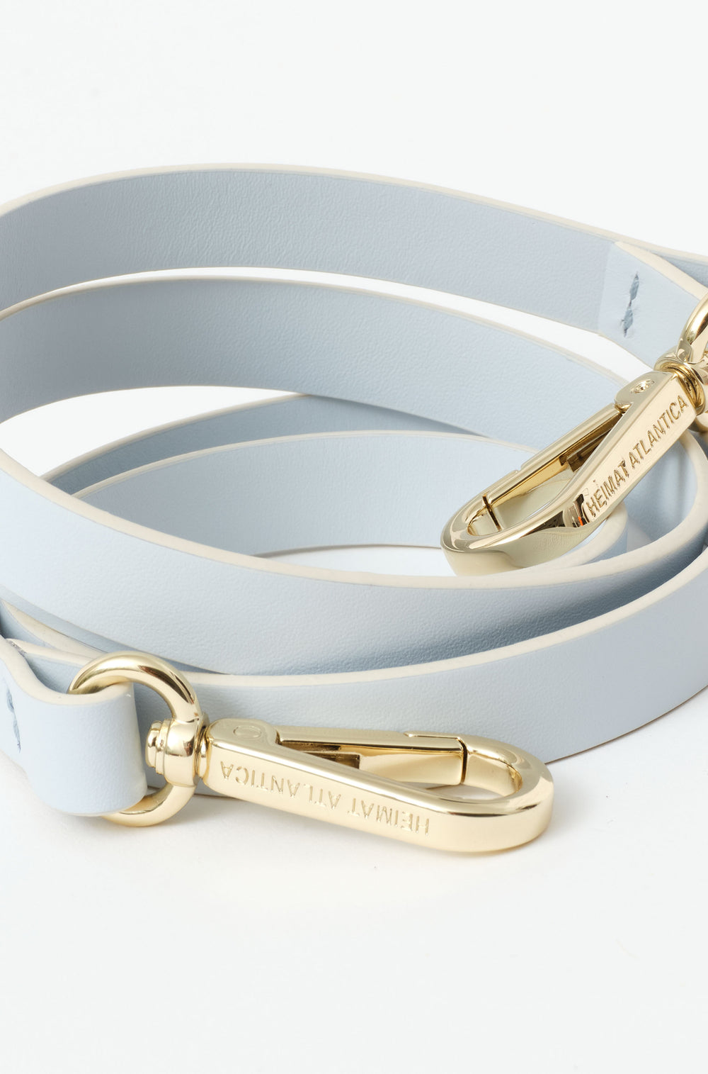 Ice blue leather strap with gold metal hardware and clasps engraved with the brand name. 