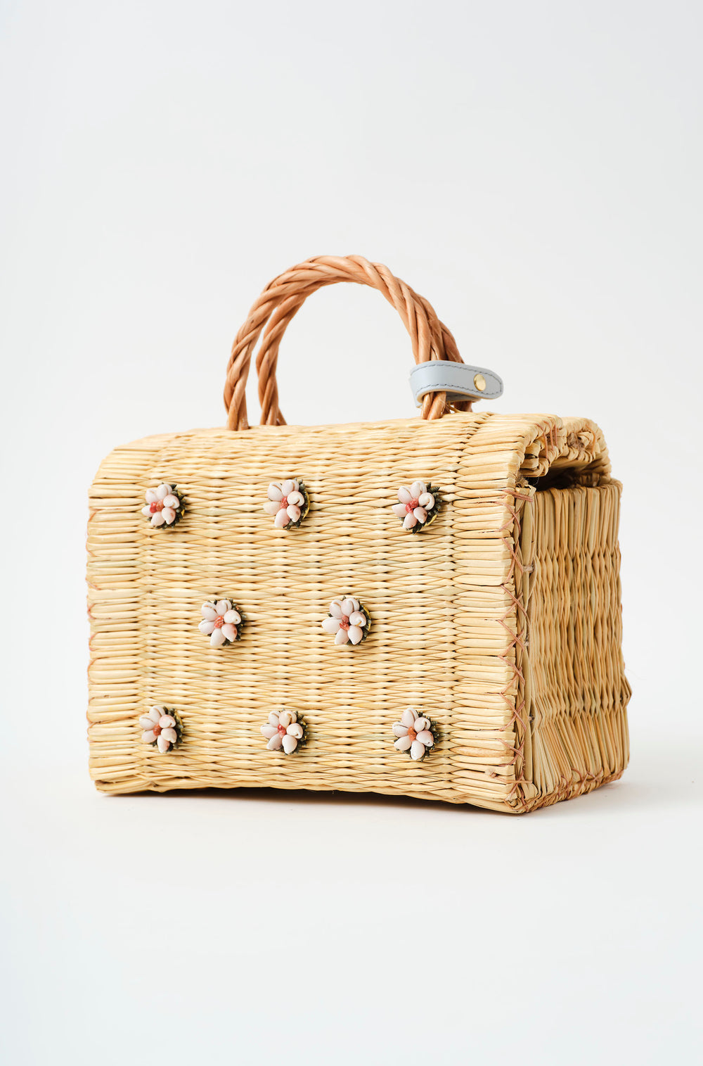Shella basket bag by Heimat Atlantica photographed on the Atlantic coast between Spain and Portugal, celebrating shell craft, handmade tradition, and contemporary design with the feet in gold. 