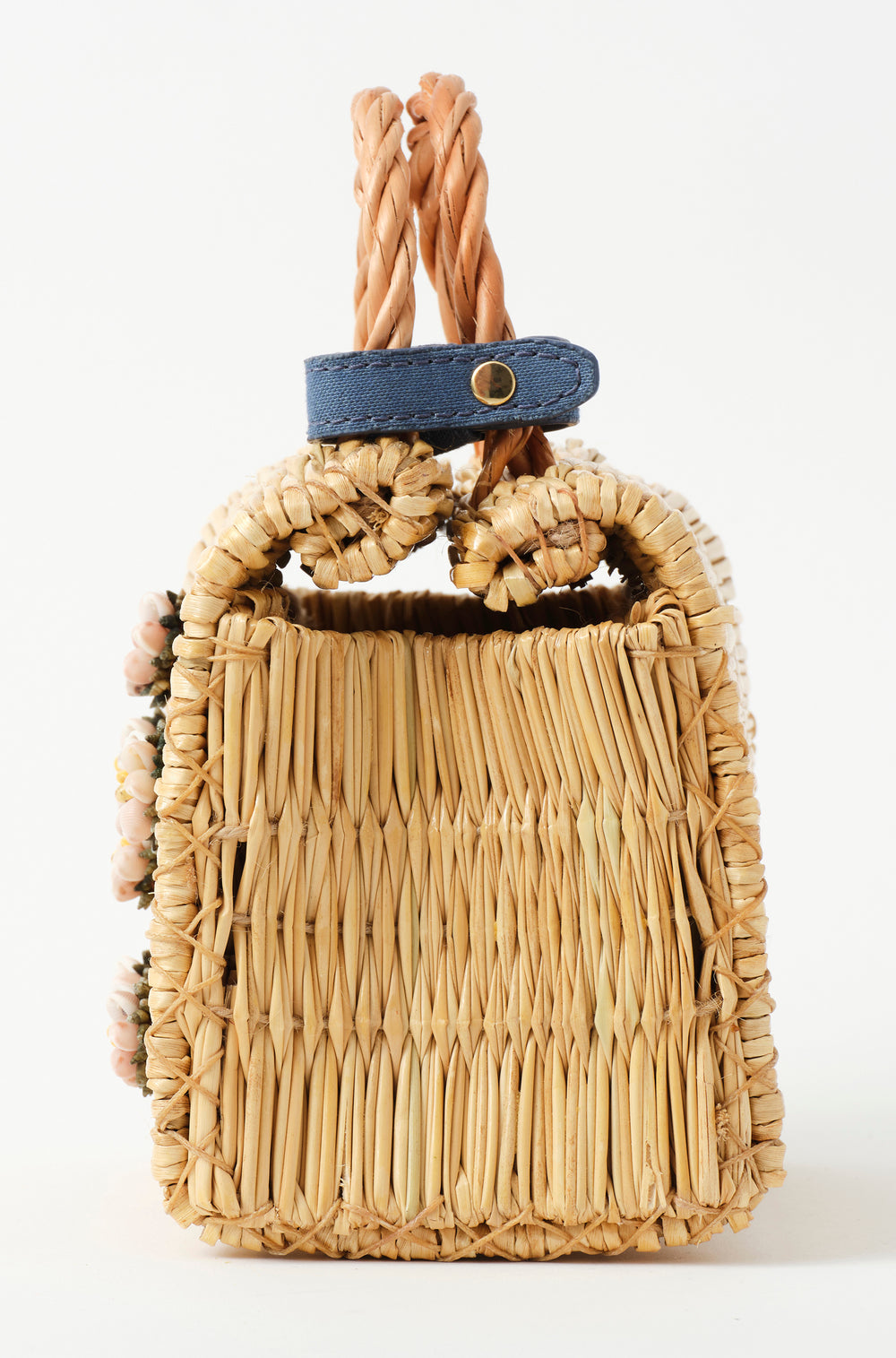 Mini Shella basket bag by Heimat Atlantica, handwoven in Portugal from reed and finished in Spain with an Atlantic shell detail. Lateral detail.