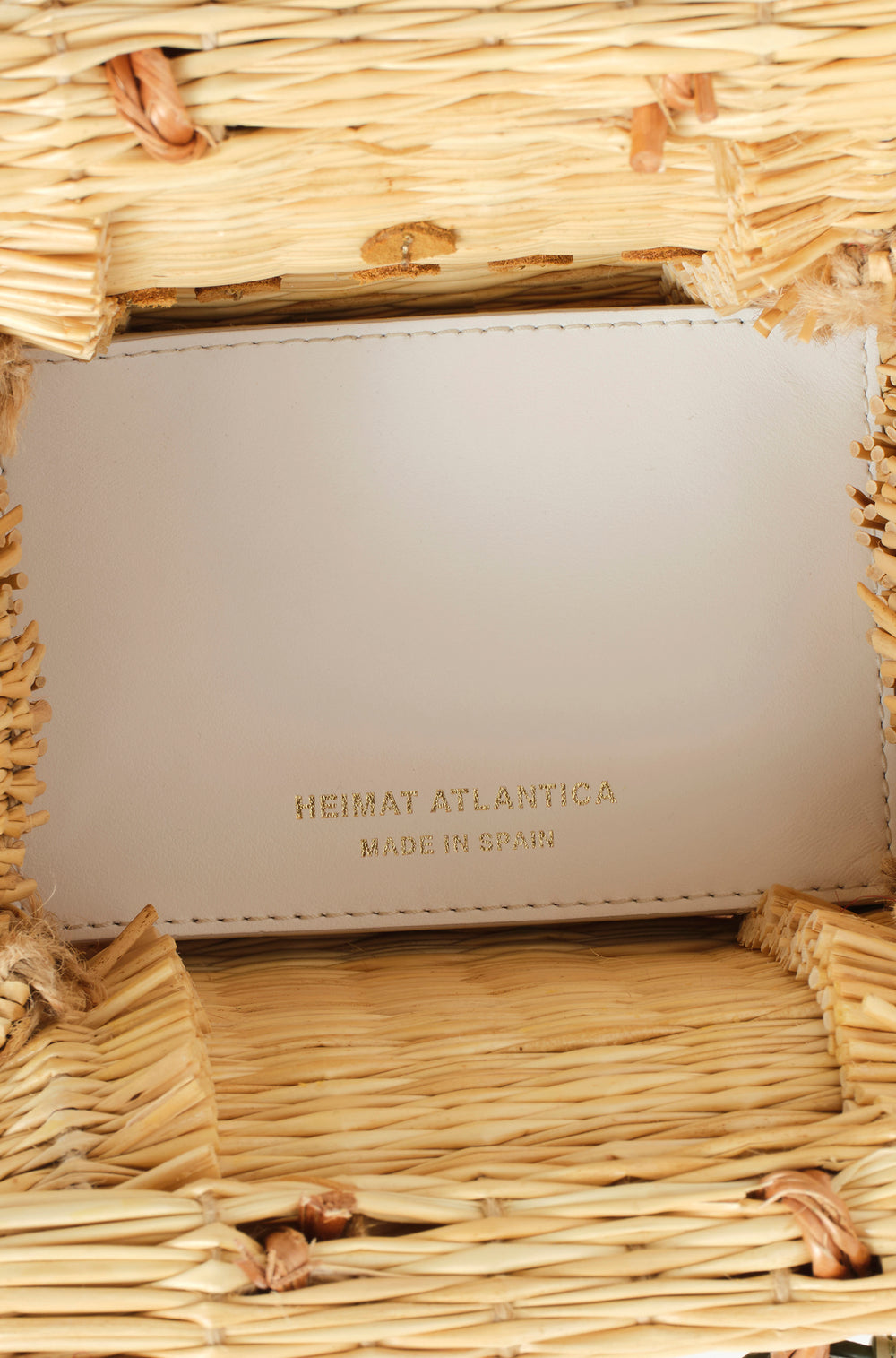 Shella Mini White basket bag by Heimat Atlantica, handwoven in Portugal from natural reed and finished in Spain with an Atlantic shell details. Interior in leather in white. 